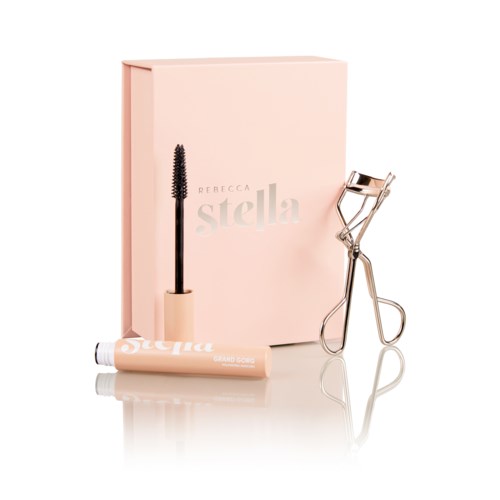 En rosa låda med makeup-prylar: mascara, ögonfransböjare och en tub, alla väl organiserade.