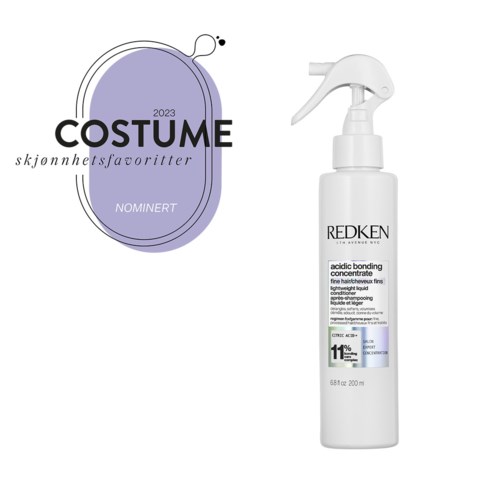 En logo for kostymepriser på en lilla form, ved siden av en hvit sprayflaske med Redken hårprodukt.