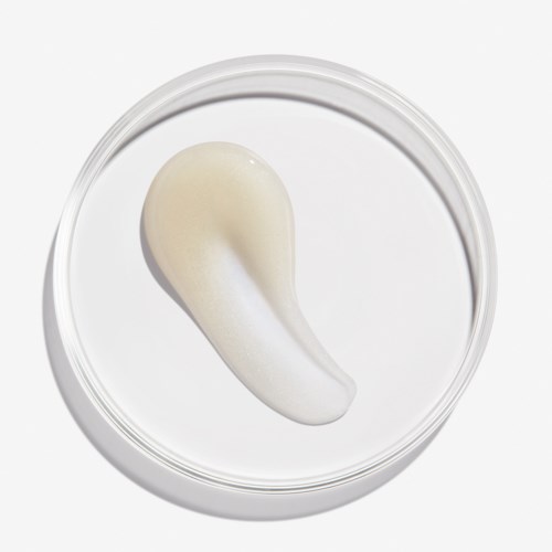 En klatt med hvit krem eller lotion i en liten beholder.