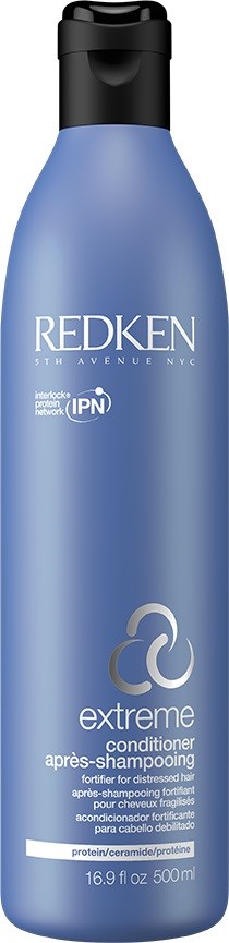 En blå flaska med Redken Extreme balsam med svart lock, märkt för hälsosamt, skadat hår, 16,9 fl oz.