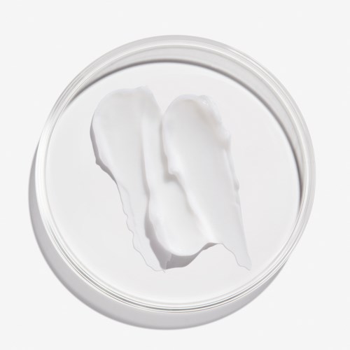 En klar beholder med hvid creme og to klatkugler indeni, set ovenfra.