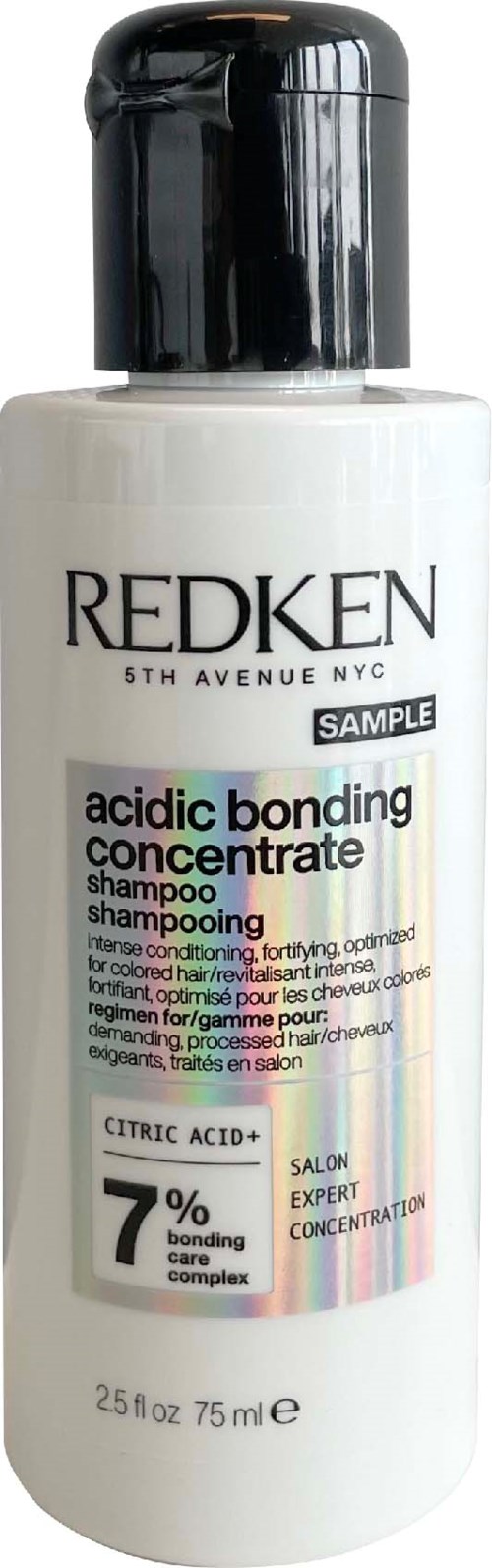 A white bottle of Redken acid bond shampoo with a black cap and colorful label detailing ingredients and brand.