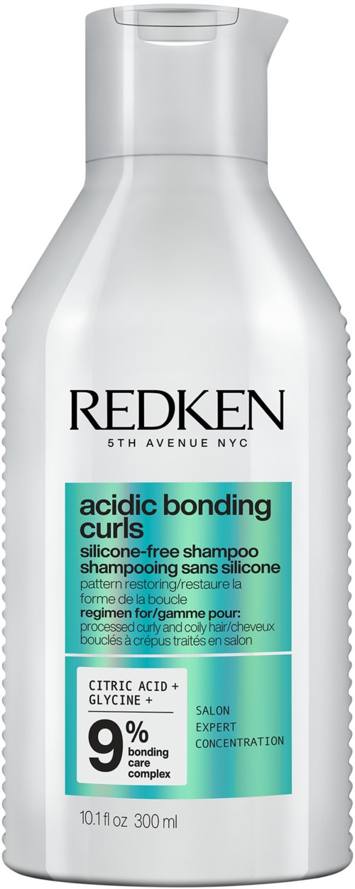 En hvid shampoo-flaske mærket 'Redken' med 'acidic bonding curls' shampoo med 9% bonding kompleks, 300 ml.