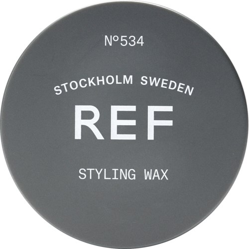 En rund grå etikett med vit text som nämner en produkt från Stockholm, Sverige, kallad REF Styling Wax, nummer 534.