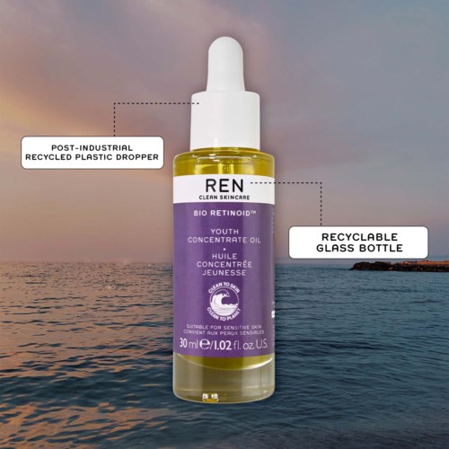 A skincare serum in a clear glass bottle with a dropper, labeled 'REN Youth Concentrate Oil' on a water background.