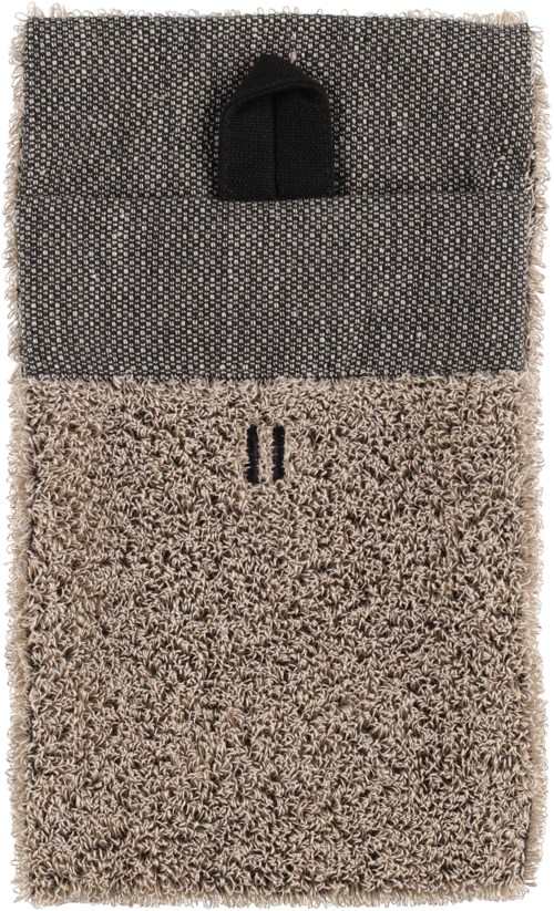 A pocket with a black handle is attached to a gray textured item, possibly a bag or cover, with a soft, fuzzy surface below.