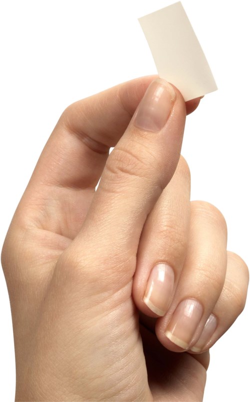 En hand håller ett litet blankt vitt papper.