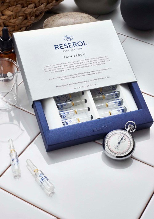 Hautpflege-Serum-Set mit kleinen Flaschen, Stoppuhr und einer RESEROL-Box auf Fliesen.