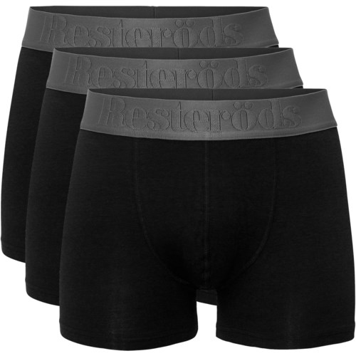 Tre svarta boxershorts med gråa midjeband staplade, visar märkesnamnet på midjebandets elastiska