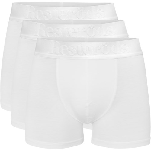 Tre vita herrunderkläder är staplade, visar midjebanden med varumärket. De är enkla och okomplicerade.