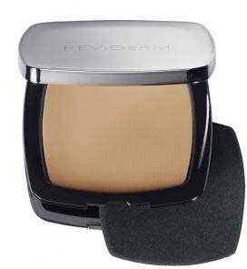 En liten makeupförpackning med beige puder, rund silverlock, och en svart bas med en svamp att applicera med.