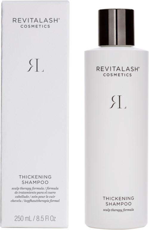En hvit flaske merket 'Revitalash Cosmetics' med svart lokk ved siden av esken, begge er for tyktende sjampo.