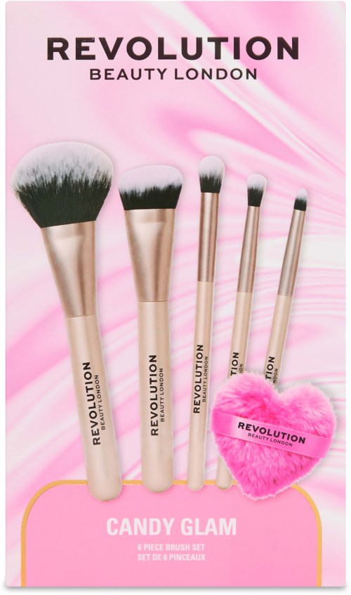 Fünf Makeup-Pinsel und Schwämmchen in Herzform in pink vom Revolution Candy Glam Set auf rosa Verpackung.