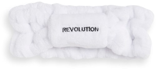 En vit kudde med ordet "REVOLUTION" broderat i mitten.