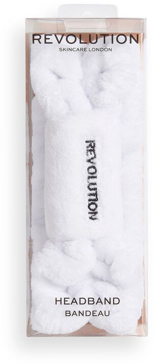 Ett vitt pannband med svart text i en genomskinlig förpackning, märkt 'Revolution Skincare London Headband.'