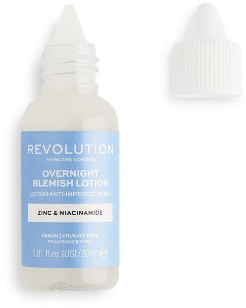 En liten vit flaska med blå etikett som säger 'Revolution' och 'overnight blemish lotion' för hudvård.