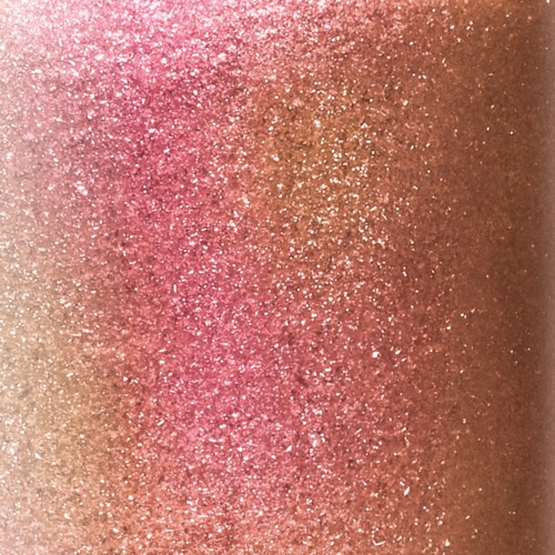 En glittrig, gnistrande yta med rosa och guld som blandas.
