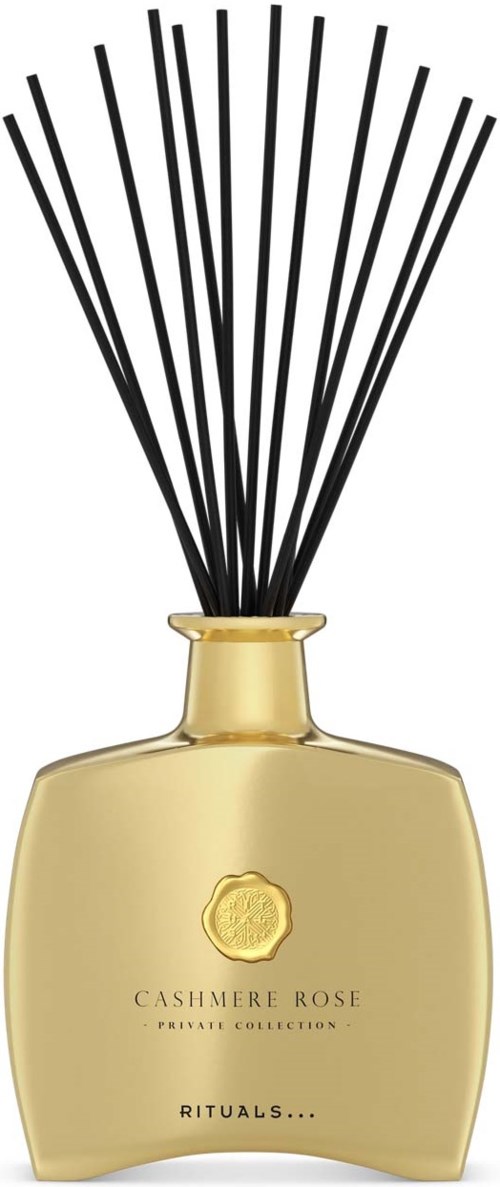 Złoty dyfuzor zapachów z czarnymi patyczkami i etykietą Cashmere Rose, relaksujący aromat.