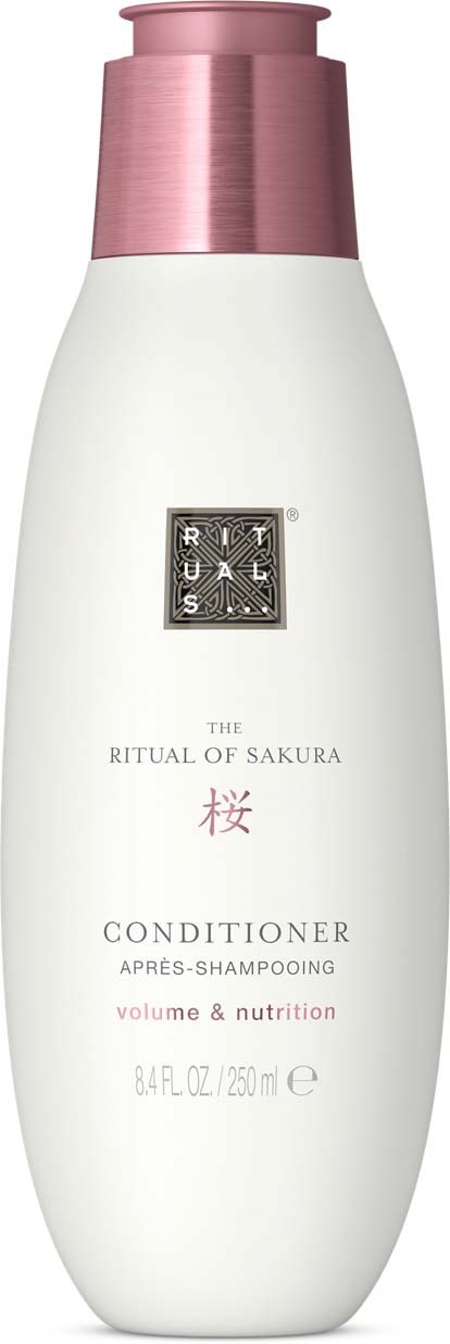 En hvit balsambottle med rosa lokk, merket 'The Ritual of Sakura', for volum og ernæring.