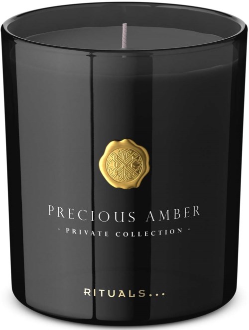 Een zwarte luxe kaars met een gouden zegel en witte tekst, gemarkeerd 'Precious Amber' uit een privécollectie.