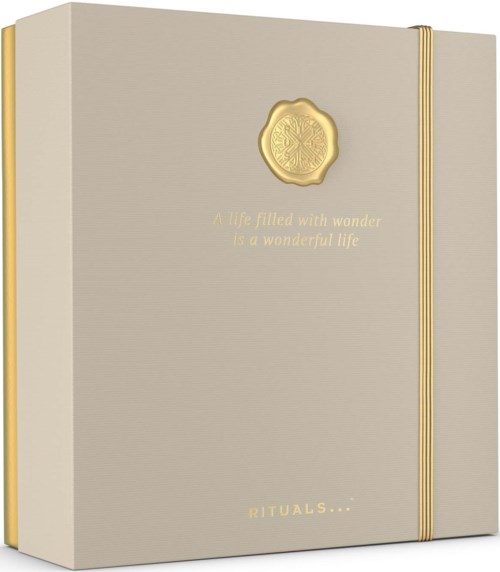 En beige boks med gyldne detaljer og et vokslogo, med citatet "A life filled with wonder is a wonderful life".
