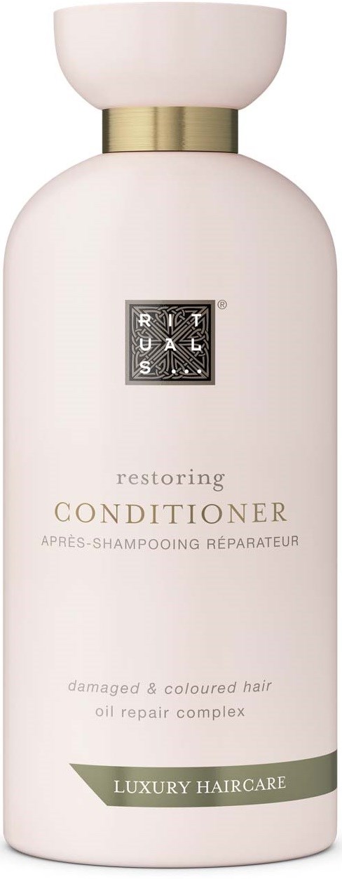 En hvit flaske merket 'Restoring Conditioner' for skadet, farget hår med oljereparasjon, del av luksuriøs hårpleie.