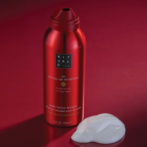 Rote Flasche mit Körperschaummousse und weißem Schaum daneben auf rotem Hintergrund.
