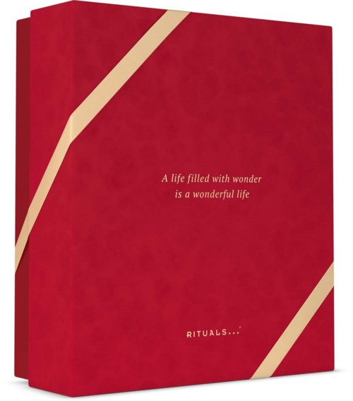 Red gift box with beige diagonal ribbons and the text A life filled with wonder is a wonderful life. Rituals logo.