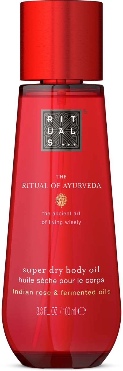A red bottle of body oil named Rituals, with text about Ayurveda, and contains Indian rose and fermented oils.