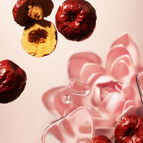 Små röda frukter och rosa rosenblad är spridda på en vit yta.