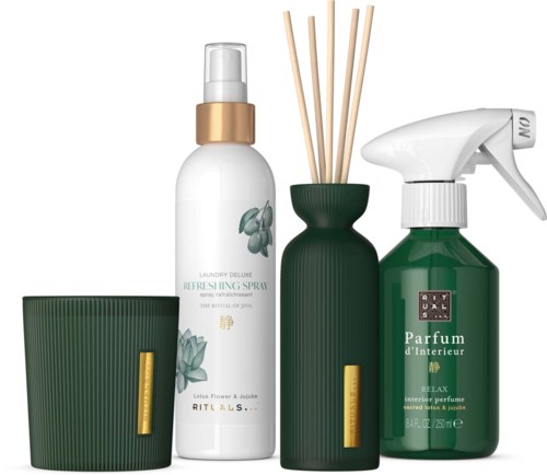 En uppsättning hemduftprodukter med ett doftljus, rumsdiffusor och spray i gröna och vita flaskor.