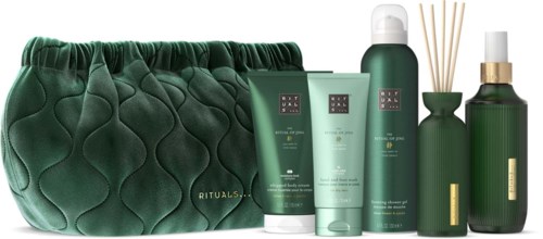 A green luxury toiletry bag with skincare and body care products, some with pump tops and reed diffusers.