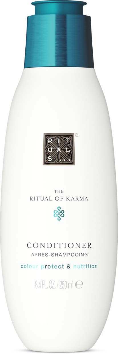 En hvit flaske med blå lokk, merket som balsam, fra The Ritual of Karma for fargebeskyttelse.