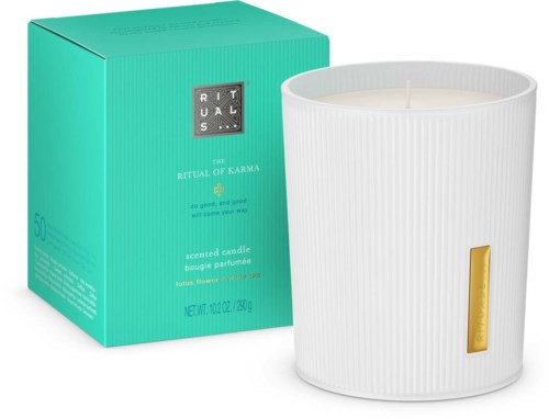 Een witte geurkaars in een geribbelde glazen houder, met een klein gouden label, en teal verpakkingsdoos.