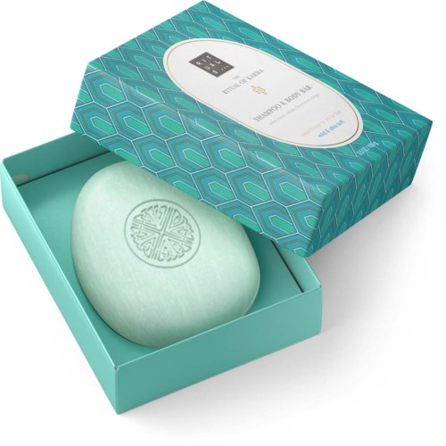 Een lichtgroen, rond stuk zeep met een ontwerp onderdruk in een open turquoise doos.