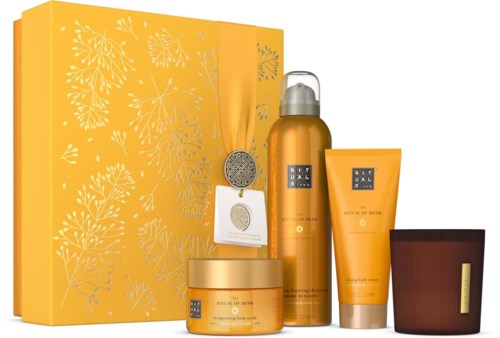 A gold-colored gift set with skincare products, a box, and decorative items, all in yellow and orange tones.