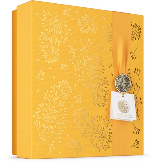 Een geel geschenkdoos met witte bladpatronen en een lint met een zilveren medaille.