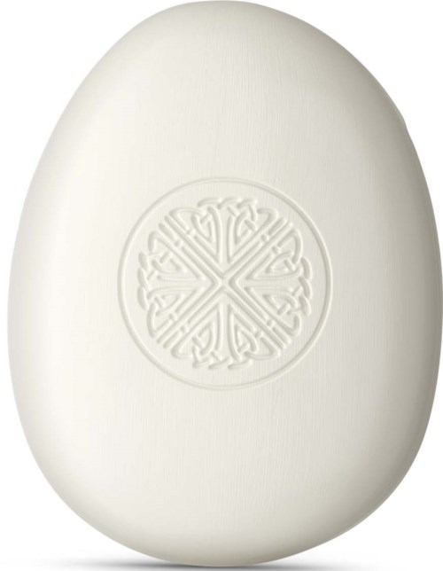 En glatt hvit oval såpe med et dekorativt preget design i midten.