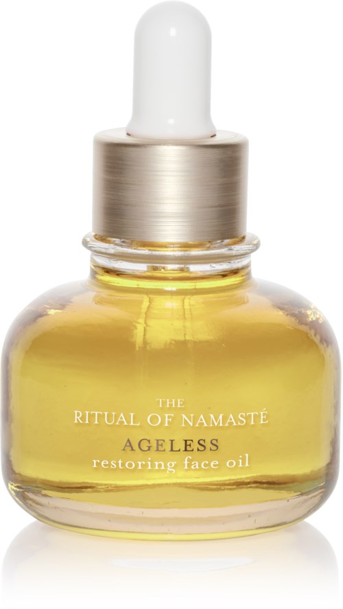 En liten glasflaska med guldfärgad ansiktsolja och en vit pipettkork. Text på flaskan säger 'The Ritual of Namaste Ageless restoring face oil.'