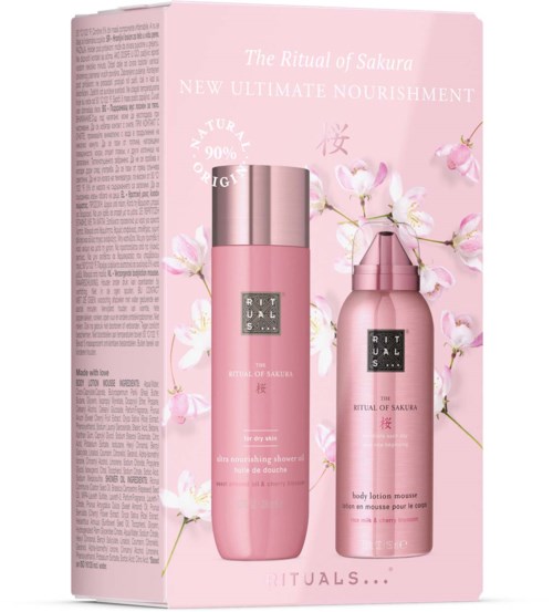 Ett rosa hudvårdsset med två flaskor, omgiven av körsbärsblommor, i en ljusrosa låda. Boxen säger 'The Ritual of Sakura'.