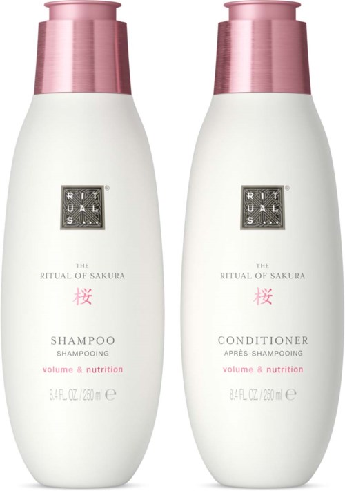 Two white bottles with pink caps, labeled as shampoo and conditioner, part of The Ritual of Sakura collection.