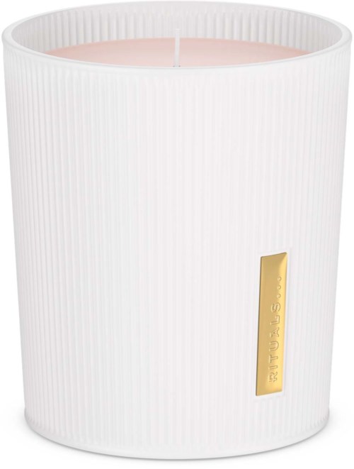 Een witte kaars in een textuurbakje met een gouden label en roze was erin.