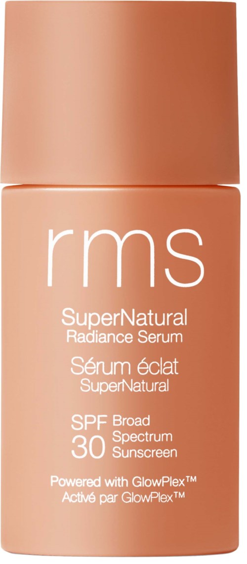 En flaska RMS SuperNatural Radiance Serum med SPF 30. Den är i en persikofärgad behållare.