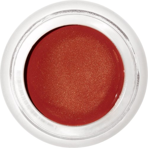 The image shows a clear glass filled with red liquid, viewed from above. The glass has a white rim.