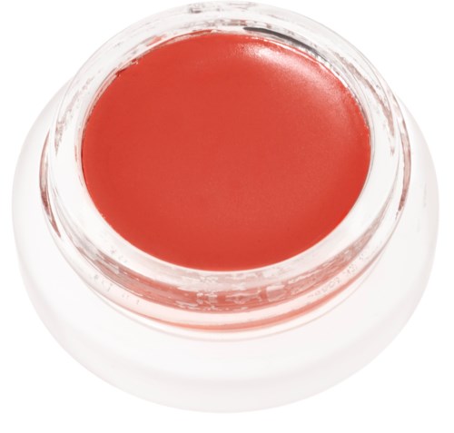 A small open jar with coral-colored cream or gel inside.