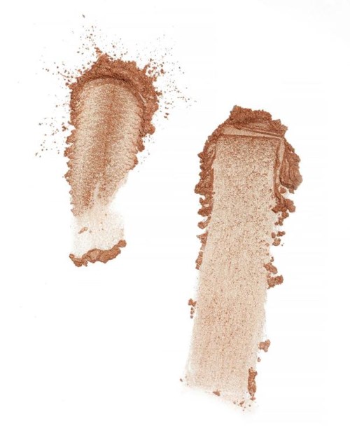 To børstestreker av brunt makeup eller pudder på en hvit bakgrunn.