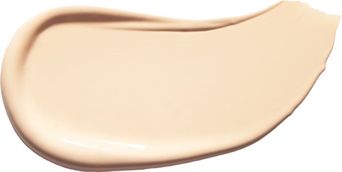 A creamy beige liquid spread out smoothly, with a rounded edge on one side and a rippled edge on the other.