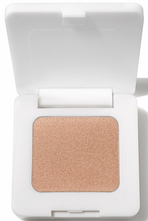 Ett litet vitt fodral med en beige ögonskugga inuti och ett öppet lock.