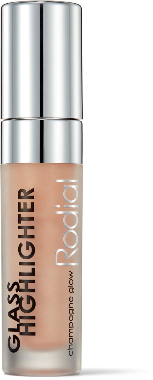 A small bottle of makeup glow highlighter with a silver cap and beige liquid inside.