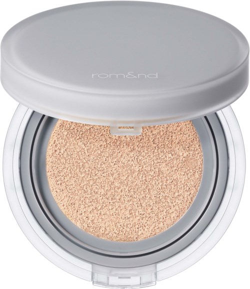 En rund hvit eske med en beige makeup-svamp innendørs, ser myk ut.
